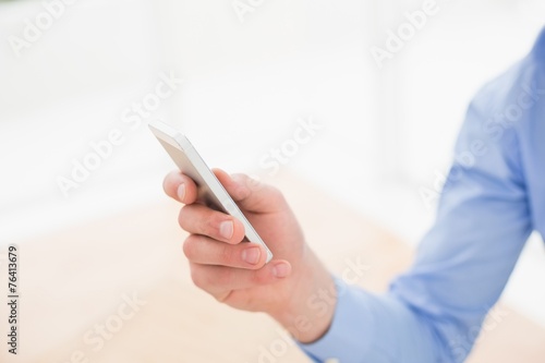 Businessman text messaging with his smartphone