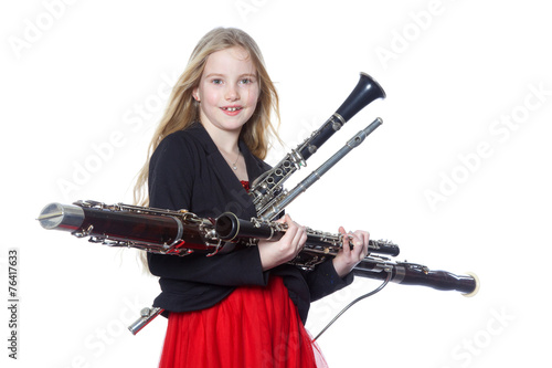 young girl holds woodwind instruments in studio © ahavelaar