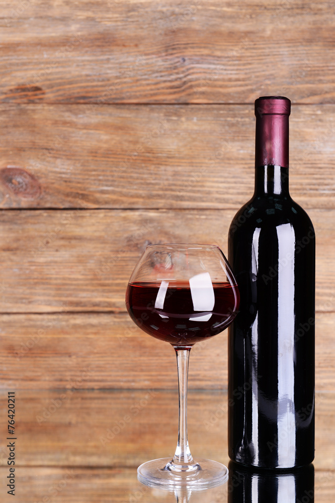 Red wine on table on wooden background