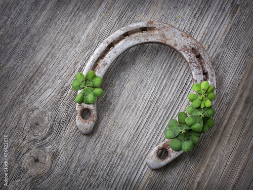 Old rusty horseshoe and four leaf clover photo