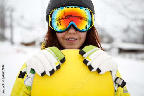 beautiful young woman posing outdoors with her snowboarding gear