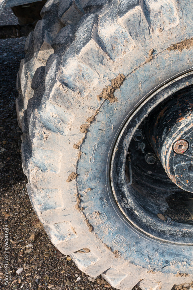 Close-up muddy loader excavator tire on the road