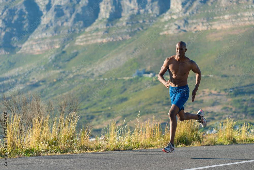 Obraz premium Athletic, black male running along a road