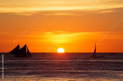 Sailboats at sunset on a tropical sea. Silhouette photo.