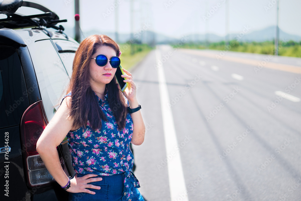 Business woman at roadside is using her mobile phone to communic Business woman at roadside is using her mobile phone to communic