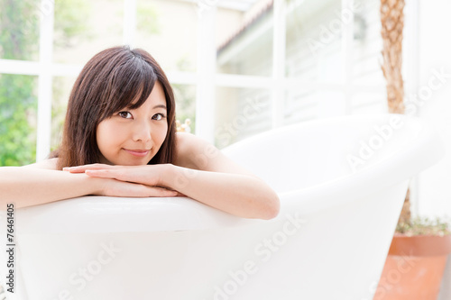 young asian woman relaxing in the bathtub