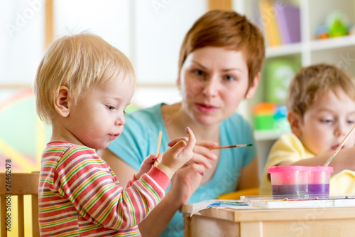 woman teaching children to paint