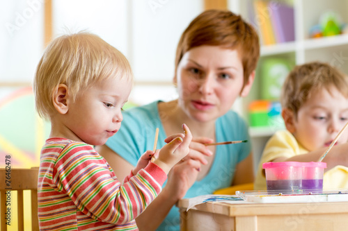 woman teaching children to paint © Oksana Kuzmina