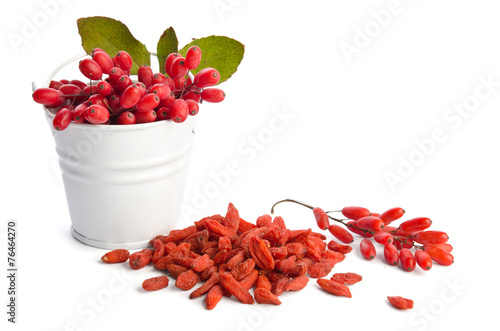 heap of goji berries near bowl of berberries photo