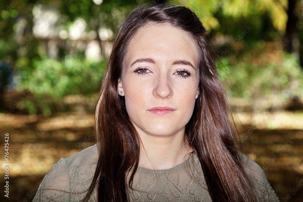Woman with long hair in front of colorful trees in autumn