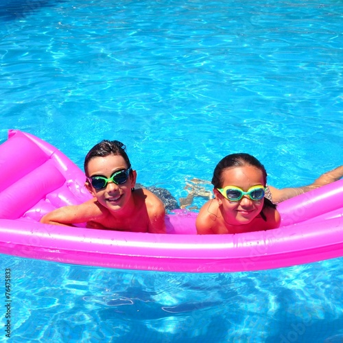 Niños en piscina sobre colchoneta fucsia