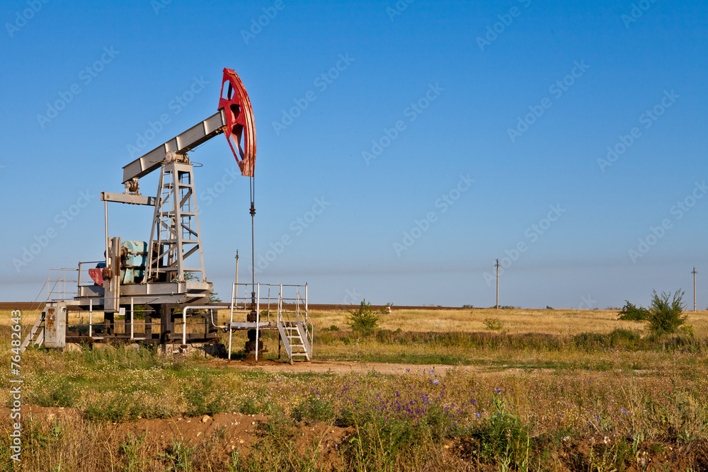 Oil pump on a background of blue sky Oil pump on a background of blue sky