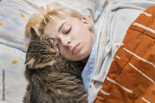 The woman asleep in bed with the cat