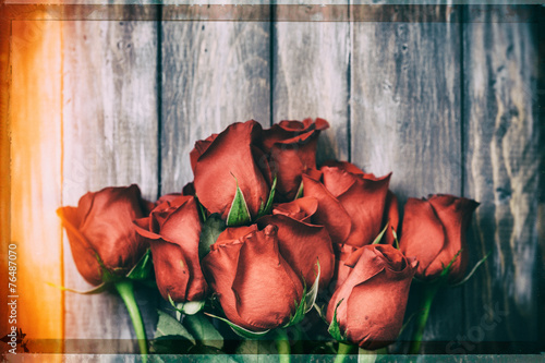 Valentine: Grunge Overhead Of A Dozen Roses On Wood Background