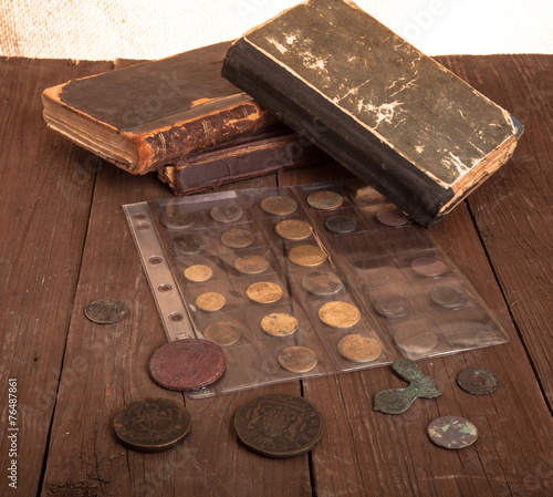 Vintage books and coins on old wooden table
