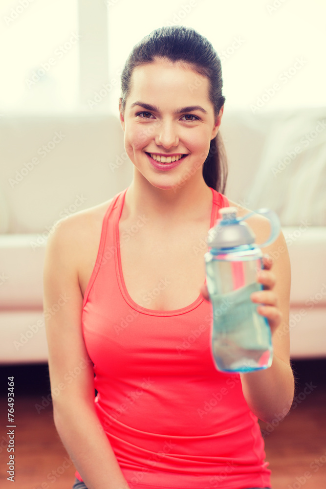 smiling girl with bottle of water after exercising smiling girl with bottle of water after exercising