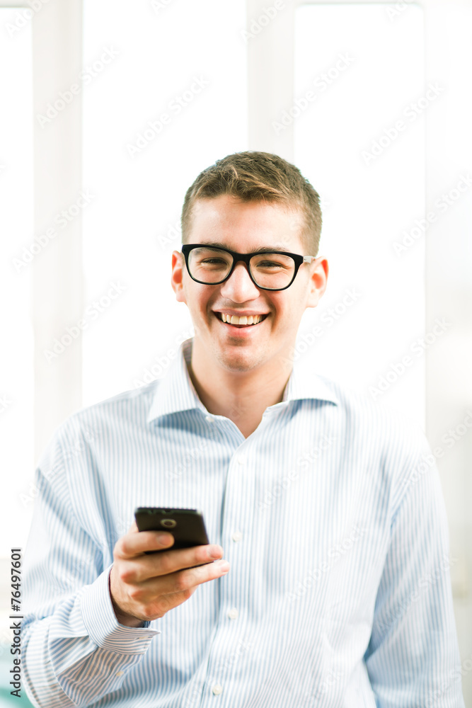 Close-up portrait of a casual young man using mobile phone