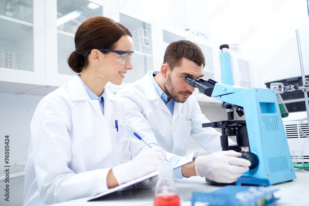 scientists with clipboard and microscope in lab scientists with clipboard and microscope in lab