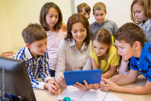 group of kids with teacher and tablet pc at school