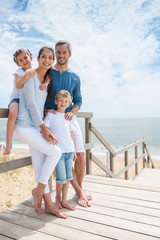 happy family  standing on a wood pontoon in front of the sea