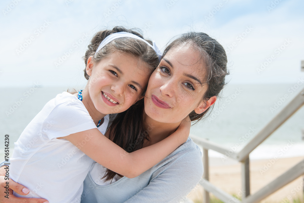 beautiful mom and her daugther at seaside smiling at camera beautiful mom and her daugther at seaside smiling at camera
