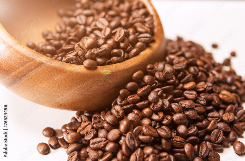 Obraz premium Closeup of Wooden Bowl with Heap of Arabica Coffee Beans on Whi