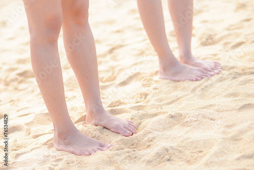 two girl barefoot on the beach