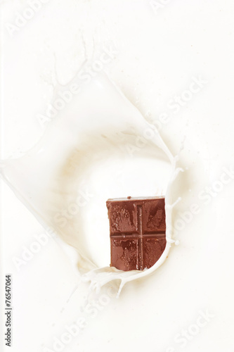 Dark chocolate splashed into fresh milk with white background.