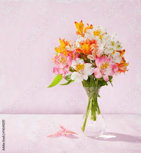 Fototapeta Naklejka Na Ścianę i Meble -  Bouquet of Alstroemeria in glass vase on light pink background