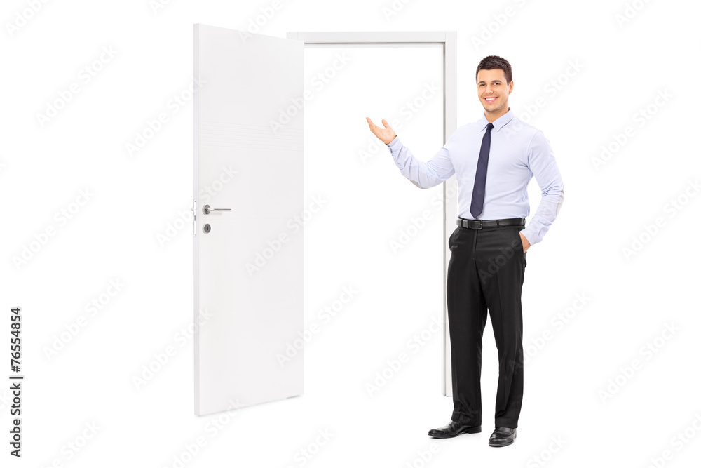 Young man pointing towards an opened door Young man pointing towards an opened door