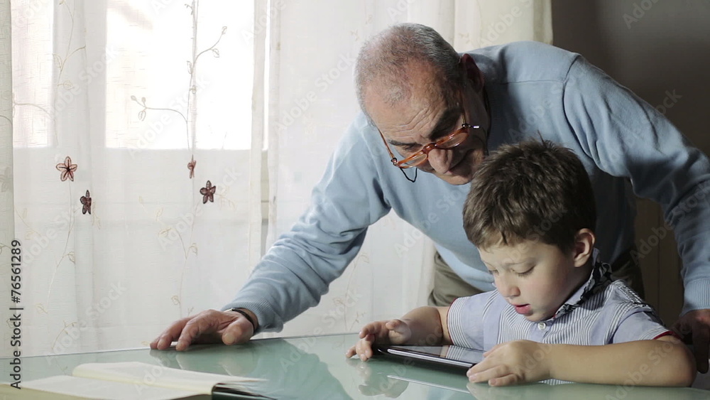Grandfather and grandson using digital tablet together Grandfather and grandson using digital tablet together