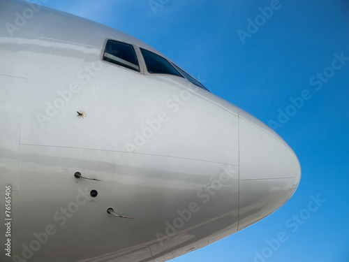 Airplane nose close up isolated on blue sky