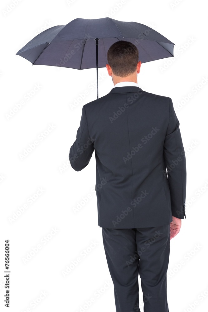 Businessman sheltering under black umbrella Businessman sheltering under black umbrella