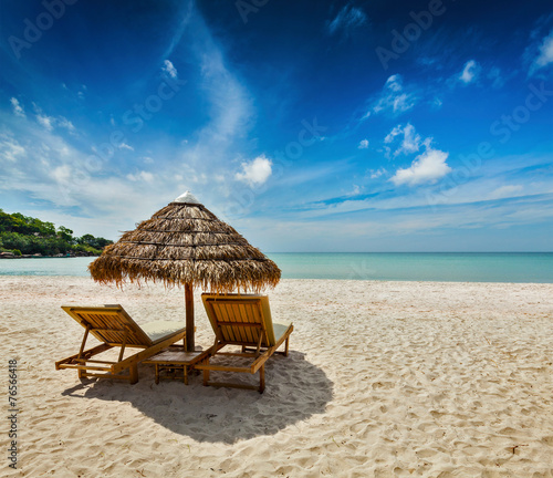 Two beach lounge chairs under tent