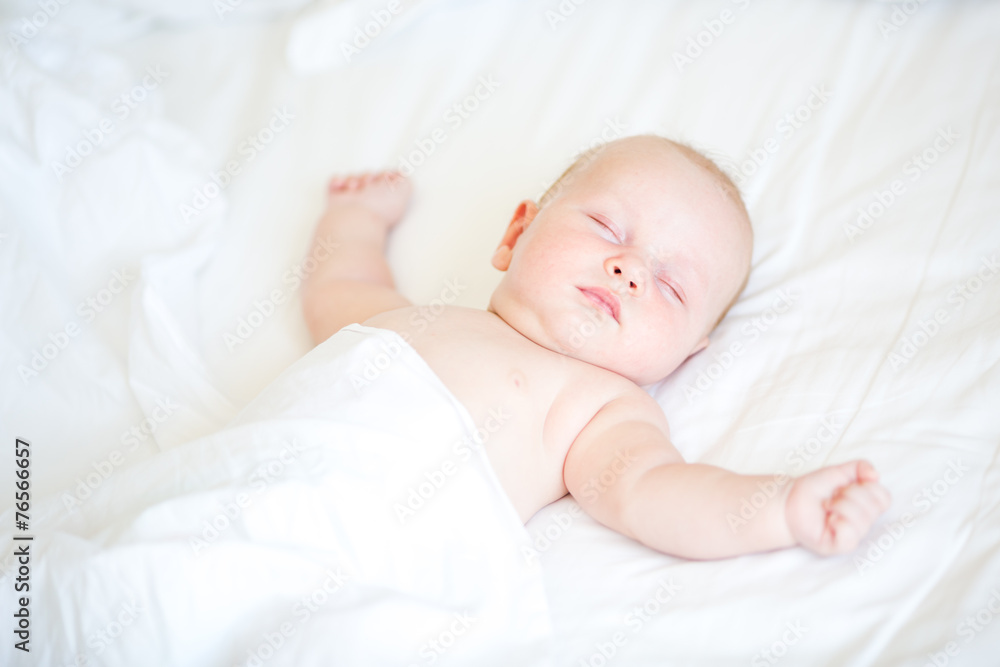 Peaceful newborn baby lying on a bed sleeping Peaceful newborn baby lying on a bed sleeping