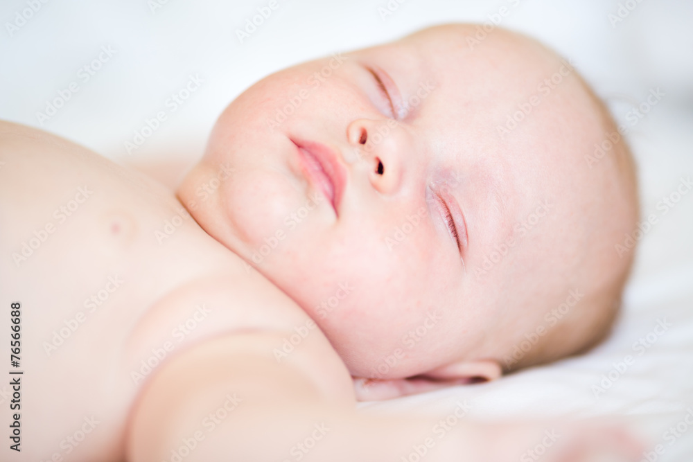 Peaceful newborn baby lying on a bed sleeping Peaceful newborn baby lying on a bed sleeping