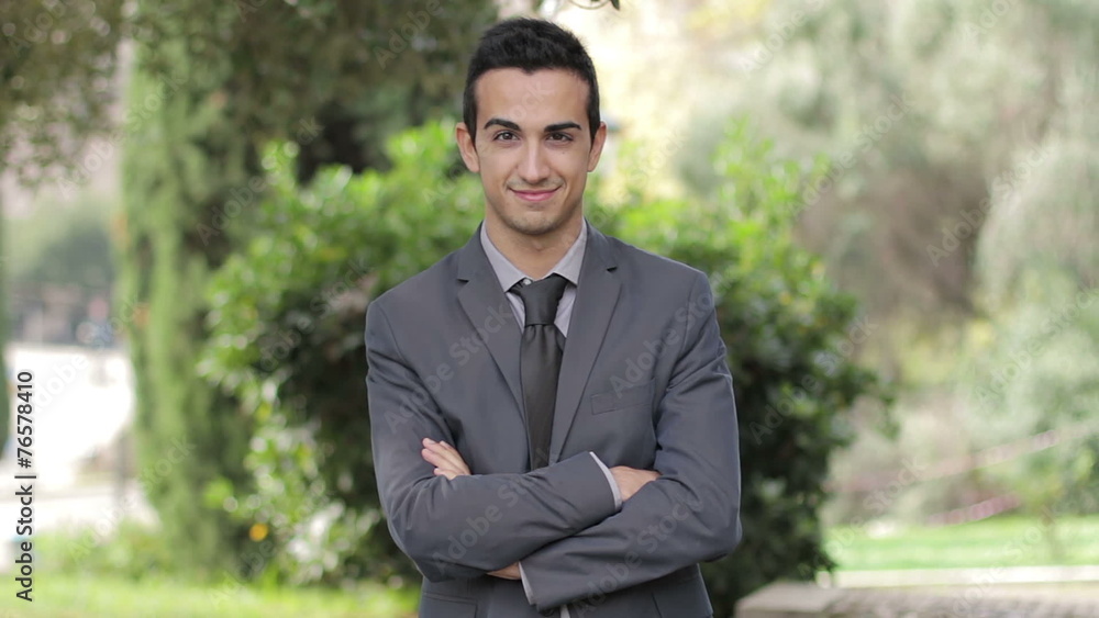 Satisfied smiling young businessman. In park Satisfied smiling young businessman. In park