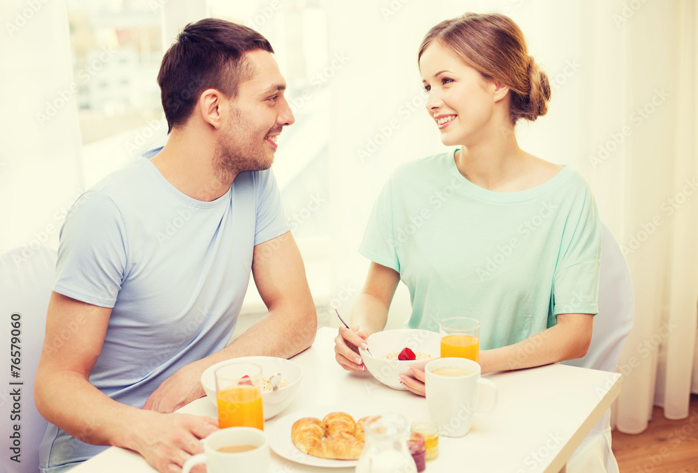 smiling couple having breakfast at home