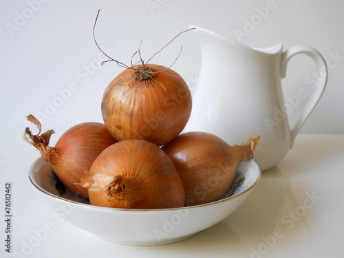 Brown onions in a bowl. photo