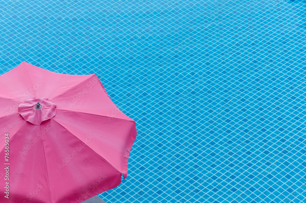 red umbrella on swimming pool in summer
