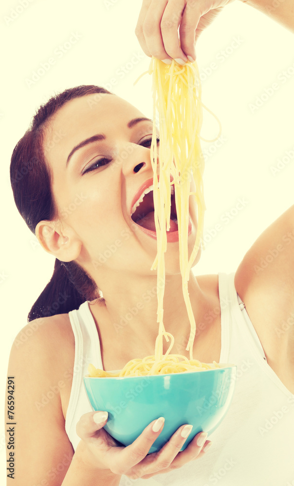 Young beautiful woman eating raw pasta. Young beautiful woman eating raw pasta.