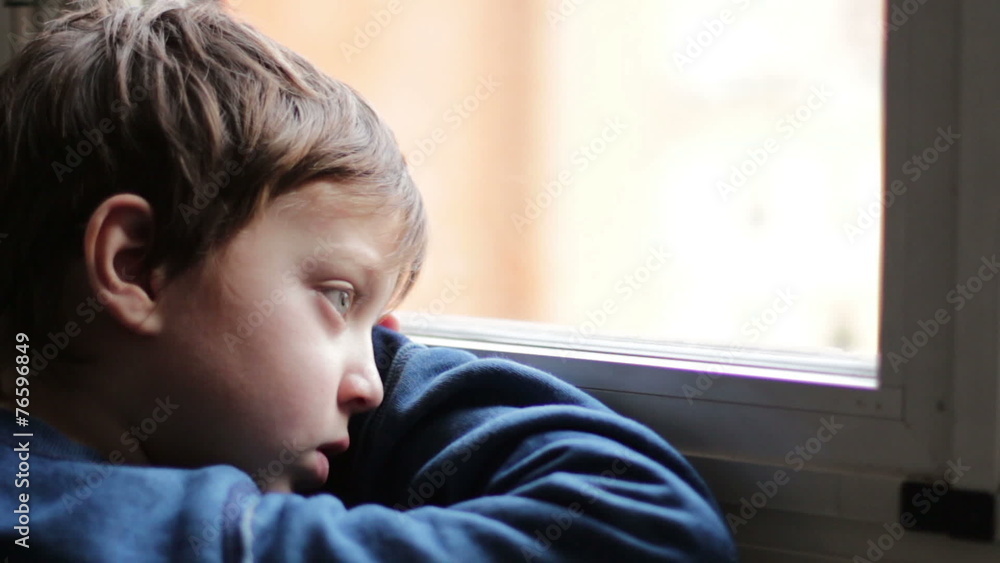 child sad and lonely looking through window child sad and lonely looking through window