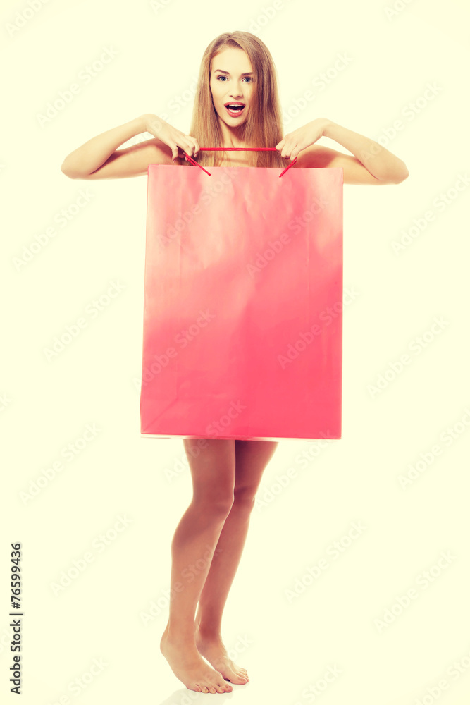 Obraz premium Naked beautiful woman holding shoping bag.