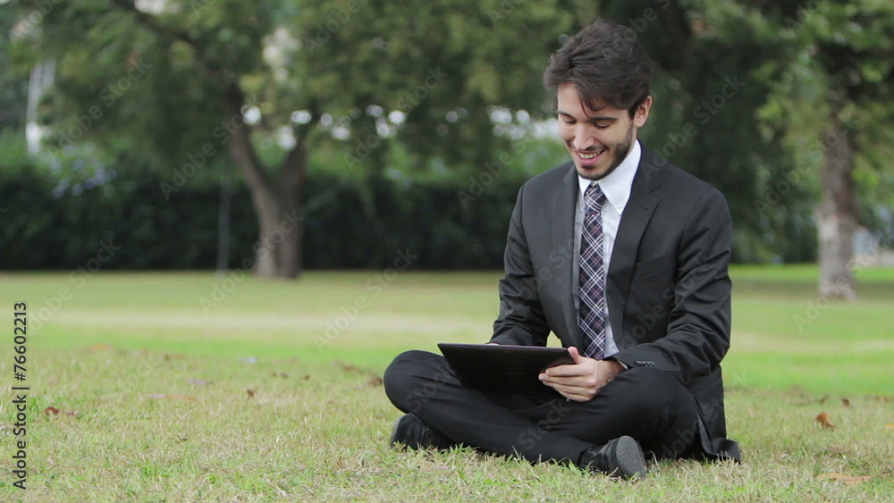 Happy business man using tablet PC outside on a park Happy business man using tablet PC outside on a park