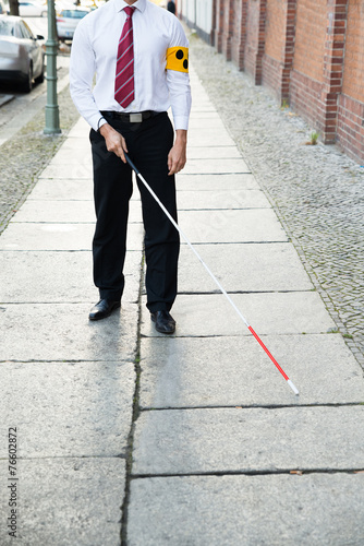 Blind Man Walking On Sidewalk photo