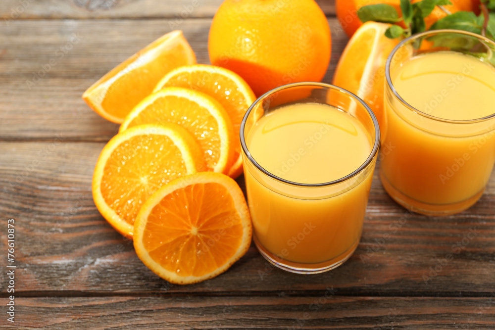 Glass of orange juice and slices on wooden table background Glass of orange juice and slices on wooden table background