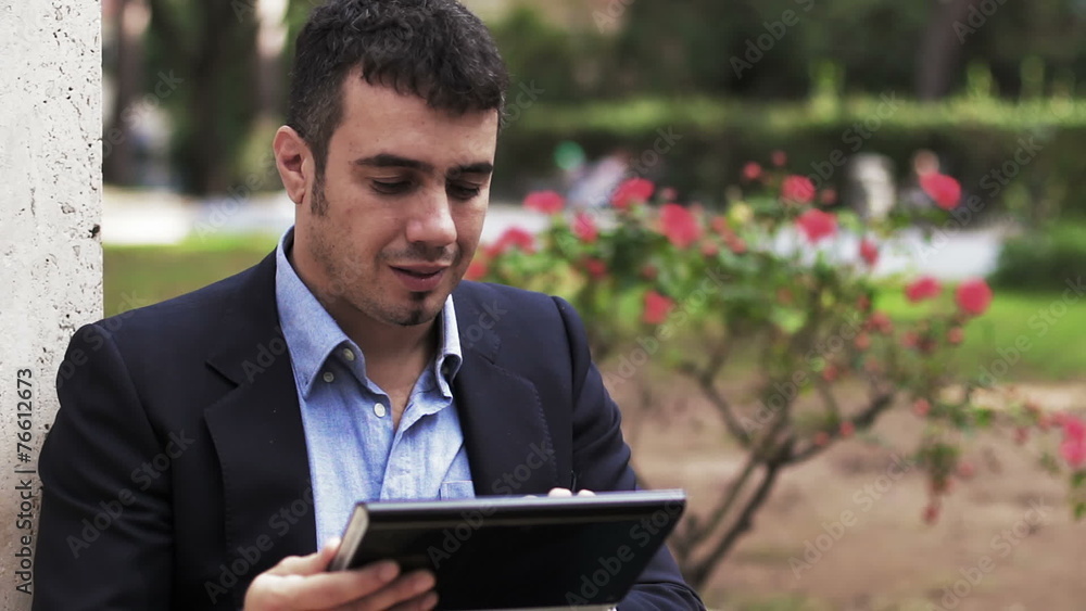 Man at a park using a computer tablet computer