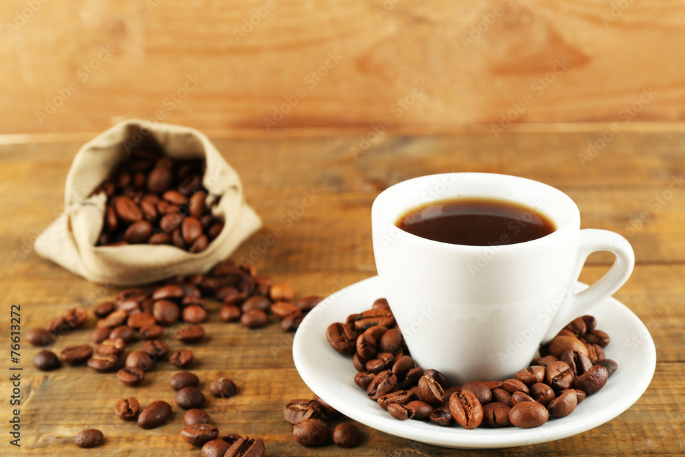 Cup of coffee with beans on rustic wooden background Cup of coffee with beans on rustic wooden background