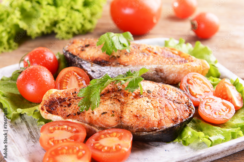 Tasty baked fish on plate on table close-up Tasty baked fish on plate on table close-up