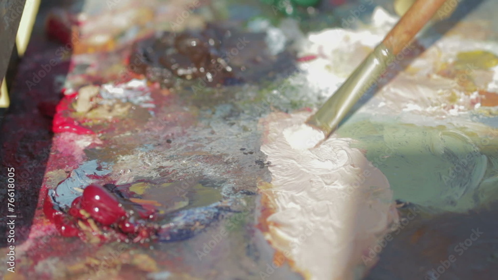 painter mixes with the brush colors in his palette painter mixes with the brush colors in his palette